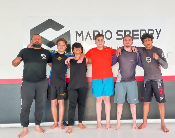 Alunos iniciantes com o professor no tatame
